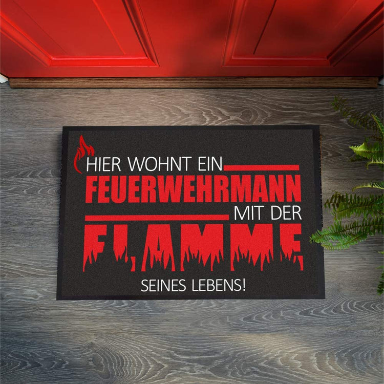 Fußmatte Hier wohnt ein Feuerwehrmann mit der Flamme seines Lebens!